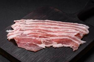 fresco cru bacon cortar para dentro fatias com sal, especiarias e ervas foto