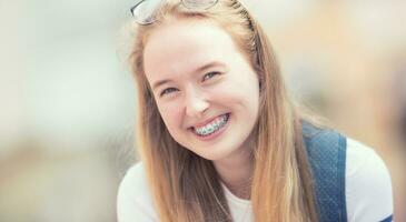 retrato do uma sorridente lindo Adolescência menina com dental suspensórios foto