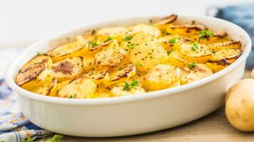 assado batatas com especiarias e ervas em cozinha mesa foto