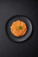 delicioso fresco massa consistindo do fino Macarrão, vermelho pesto Rosso molho com especiarias e ervas foto