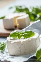 queijo Camembert ou brie queijo com manjericão folhas em mesa foto