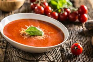 quente tomate sopa parmesão queijo e manjericão sair em velho oal mesa foto