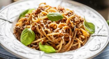 italiano massa espaguete bolonhesa servido em branco prato com parmesão queijo e manjericão foto