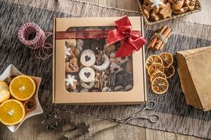 caixa cheio do Natal doce cokies e pastelaria com vermelho fita foto