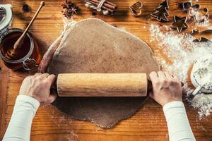 Pão de gengibre massa e mulher mãos preparando Natal bolacha bolos foto