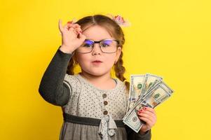 uma linda garota se surpreende com tanto dinheiro, uma criança e muito dinheiro. foto