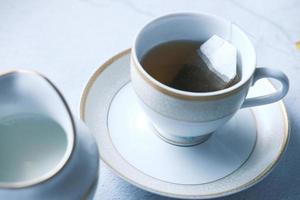 chá verde com saquinho de chá no fundo de azulejos foto