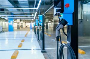 estação de carregamento de carro elétrico para carregar bateria ev. plugue para veículo com motor elétrico. carregador ev. energia limpa. ponto de carregamento no estacionamento. poder Verde. tecnologia de transporte do futuro. foto