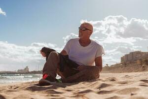 bonito meio envelhecido homem relaxante sentado em uma de praia dentro Tarragona, Espanha - turismo e feriados conceito foto