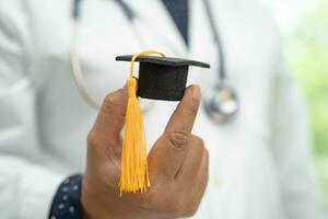 estudo de médico asiático aprende com chapéu de graduação na enfermaria do hospital, conceito de medicina de educação de gênio brilhante inteligente. foto