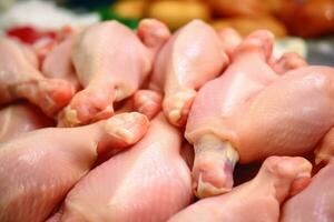 fechar acima do cru frango pernas em uma mesa ai gerado foto