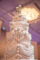 bolo de casamento branco com decoração de flor vermelha foto