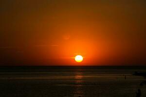 lindo dramático Sombrio pôr do sol acima a mar foto