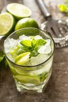 Mojito coquetel beber com branco rum Lima hortelã ervas e refrigerante em a Barra contador foto