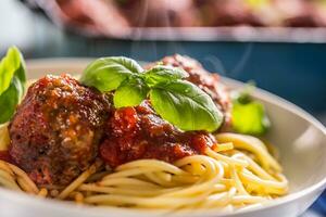 delicioso italiano refeição carne carne bolas com massa espaguete e manjericão dentro branco placa. foto