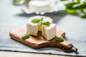 queijo Camembert ou brie queijo com manjericão folhas em mesa foto