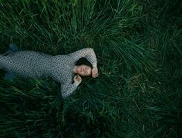 jovem menina deitado em verde trigo campo foto