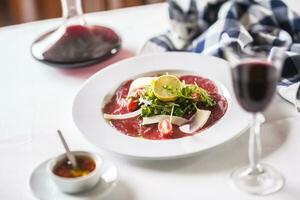 carpaccio com tomates Rúcula parmesão limão e vermelho vinho foto