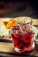 coquetel negroni em uma velho de madeira borda. beber com Gin, campari martini Rosso e laranja foto