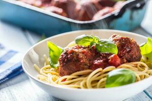 delicioso italiano refeição carne carne bolas com massa espaguete e manjericão dentro branco placa. foto