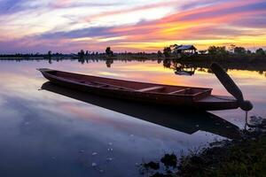 barco em a lago com pôr do sol fundo foto