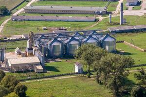 aéreo panorâmico Visão em agroindustrial complexo com silos e grão secagem linha para secagem limpeza e armazenamento do cereal cultivo foto