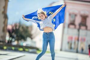 atraente feliz jovem menina com a bandeira do a europeu União foto