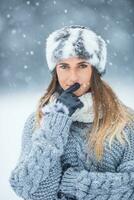 retrato do jovem lindo mulher dentro inverno roupas e Forte nevando. foto