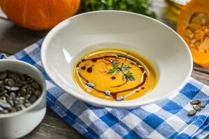 abóbora creme sopa com sementes e salsinha em cozinha mesa foto