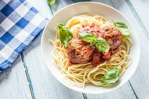 delicioso italiano refeição carne carne bolas com massa espaguete e manjericão dentro branco placa. foto