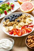 saudável café da manhã servido com prato do iogurte muesli amoras morangos e banana. foto