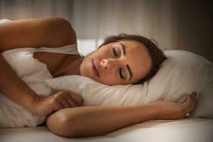 noite dormir do uma mulher com branco travesseiro debaixo dela cabeça e cobertor cobertura dela foto