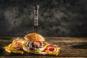 fechar-se casa fez carne hamburguer com faca e fritas em de madeira mesa foto