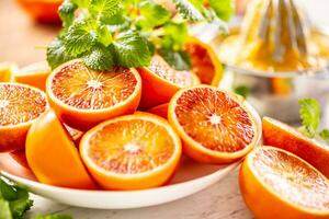 sangue siciliano laranjas fatiado em branco prato com fresco melissa foto
