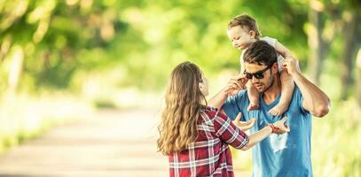 jovem pais com filha desfrutando momentos juntos dentro a parque foto