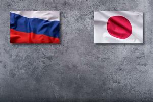 Rússia e Japão bandeiras. Rússia e Japão bandeira em concreto fundo foto