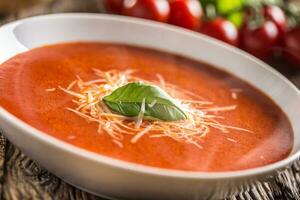 quente tomate sopa parmesão queijo e manjericão sair em velho oal mesa foto