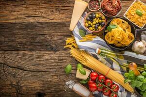 italiano Comida ingredientes massa Oliva óleo parmesão queijo manjericão alho cogumelos tomates azeitonas em de madeira mesa foto