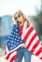 atraente feliz jovem menina com a bandeira do a Unidos estados do América foto