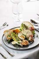 moderno versão do uma cesar salada com camarão servido dentro uma elegante restaurante foto