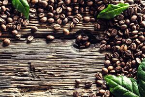 topo do Visão café feijões e verde folhas em rústico carvalho mesa foto