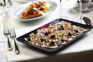 italiano Aperitivo com vitela fatias, atum salsa e azeitonas servido dentro a italiano restaurante foto