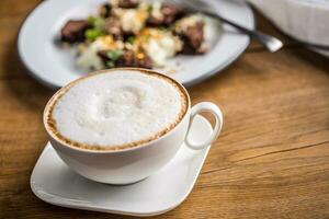 cappuccino com Brownie em mesa dentro cafeteria foto