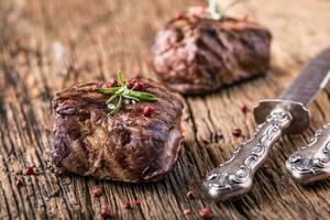 grelhado carne bife com alecrim, sal e Pimenta em velho corte borda. carne filé mignon bife. foto