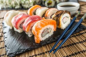 conjunto do lista Sushi ouro Califórnia com pauzinhos e soja molho. foto