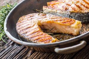 salmão. grelhado peixe salmão. grelhado salmão bife dentro assado panela em rústico de madeira mesa foto