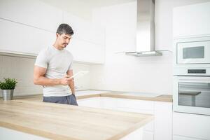 jovem homem dentro casa cozinha com tábua foto