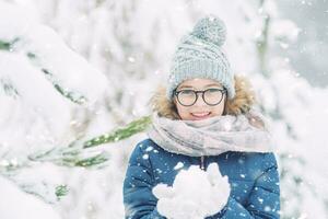 jovem menina jogando com neve dentro gelado inverno parque ou ao ar livre. foto