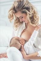 mãe amamentação dela pequeno bebê dentro dela braços foto