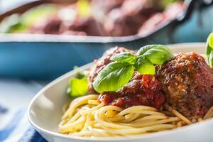 delicioso italiano refeição carne carne bolas com massa espaguete e manjericão dentro branco placa. foto